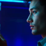 A person engaging with a glowing holographic AI interface in a high-tech room with neon accents.